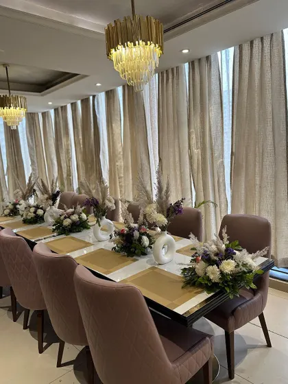 Elegant table settings for a private dining area at the restaurant launch, featuring floral centerpieces with pampas grass.