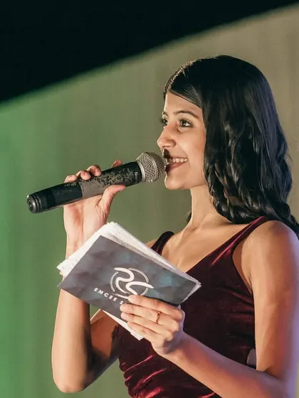 A candid shot from a reception, holding my cue cards and interacting with the audience. Being prepared allows me to be spontaneous and connect genuinely with the crowd.