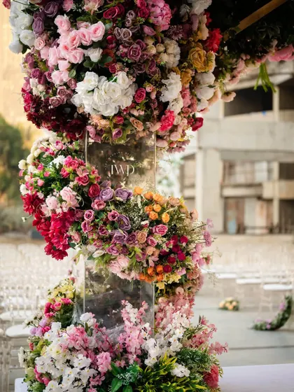 Detail of the floral spiral on the pillar of the upside down garden mandap. This shows the intricate craftsmanship involved in weaving countless flowers into a seamless, artistic structure for a luxury wedding.