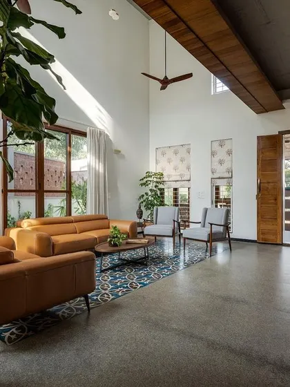 The entrance view shows how the living room opens up, inviting you in. The large wooden pivot doors can be opened completely to merge the interior with the semi-covered verandah, enhancing the indoor-outdoor feel.