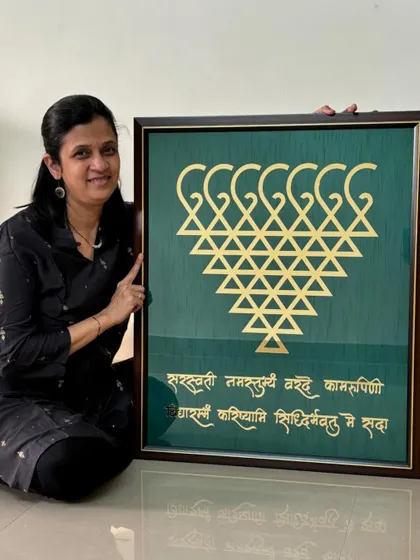 Here I am with a large, custom-made Saraswati frame. This piece, featuring the sacred yantra and shloka, was created to bring blessings of knowledge and peace to a client's home. I can customize the size and colors to perfectly match your space.