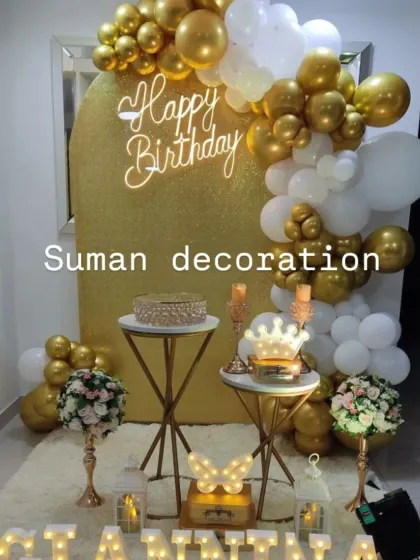 A classic white and gold birthday theme. This setup includes a gold glitter arch backdrop, balloon garland, and various props and cake stands.
