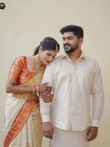 A sweet, candid photo of a bride resting her head on her groom's shoulder. This portrait captures a moment of comfort and affection between the couple in their traditional South Indian wedding attire.