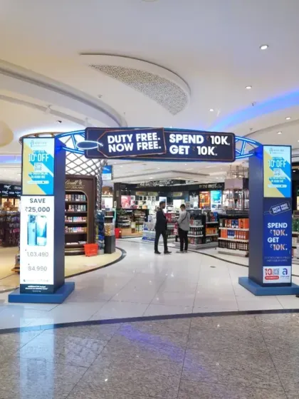 An entrance to the duty-free area featuring promotional arches and digital screens. We capture the full customer journey, including marketing efforts designed to draw people into the store.