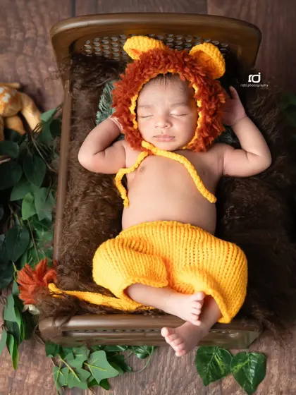 Here is our little Simba, dressed in a hand-knitted lion costume and sleeping soundly on a tiny bed in the jungle.