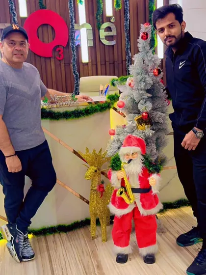 Two members standing proudly by the Christmas tree, part of our vibrant and festive community.
