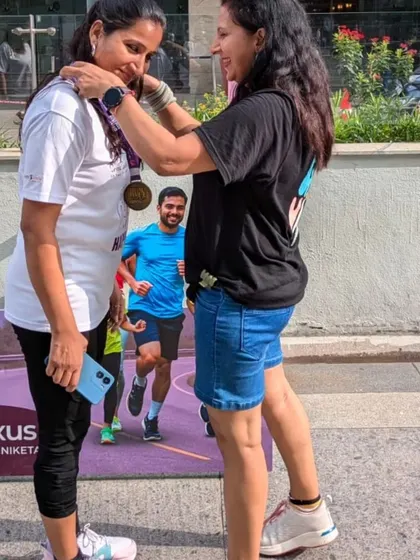 A personal moment of recognition, awarding a medal to a participant. Every runner's journey is an inspiration.