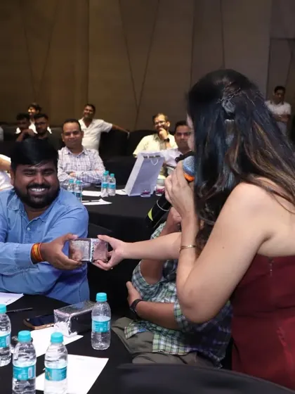 Presenting an award to a happy guest. Recognizing and rewarding audience members, whether for games or participation, is a simple way to make a corporate event more personal and memorable.