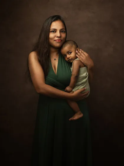 A classic mother and child portrait. The mother's protective embrace and the baby's direct gaze make for a powerful and timeless image.