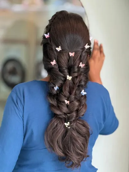 A whimsical and romantic braid by my artist Swati. The tiny, colorful butterfly clips scattered throughout the braid add a playful and unique touch.