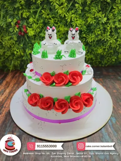 A whimsical two-tier cake with red roses and quirky frog toppers. This fun and unique design is sure to be a conversation starter at any party.