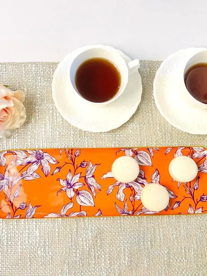 A bold, orange floral print makes this long tray a standout piece. It is perfect for adding a pop of color and energy to your serveware collection.
