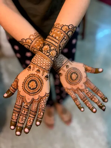 A wedding design featuring a central lotus mandala on the palm and intricate bands on the wrist.