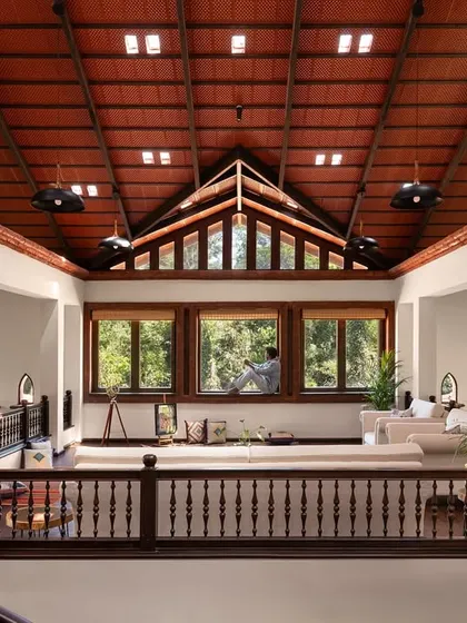 High above the main living area in the Dream Coffee Estate, this mezzanine lounge is a sanctuary in the sky. The soaring terracotta-tiled roof with integrated glass skylights, framed by hand-turned wooden balustrades, creates a serene space that feels both expansive and intimately connected to the forest canopy outside.
