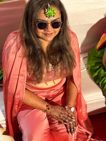 A candid shot of a client admiring her fresh henna design during a celebration.