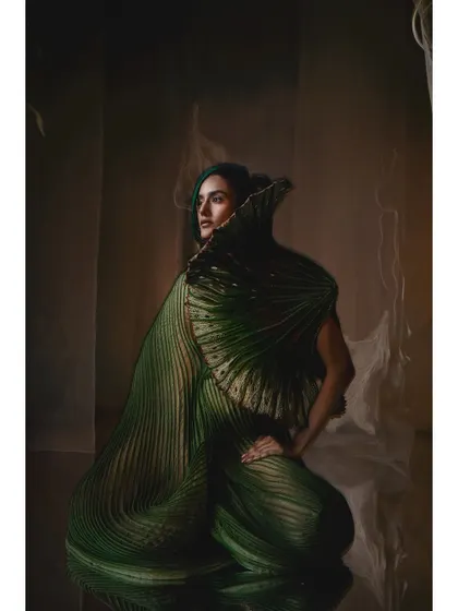 A portrait from the Vaishali S campaign featuring a green, shell-like garment. The reflective floor and ethereal background create an underwater feeling, perfectly matching the collection's narrative.