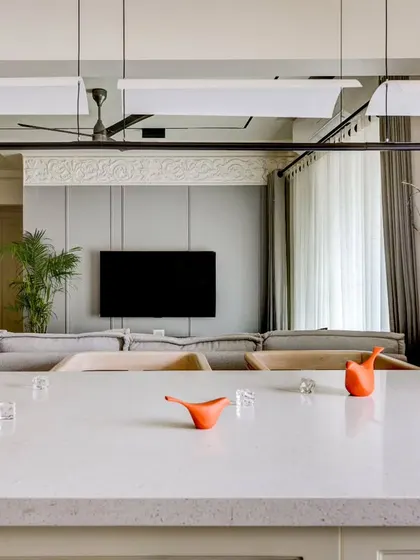 A view from the kitchen's breakfast counter towards the living room. The open-plan design allows for a seamless flow and connection between the culinary and relaxation zones.