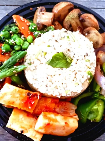 A healthy and balanced millet bowl, served with sweet chili tofu, sautéed mushrooms, and a mix of fresh, crisp vegetables.