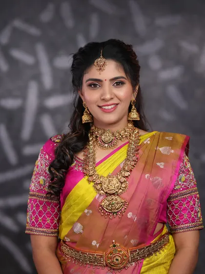 This bride looks lovely in a traditional temple jewellery set. The choker and long necklace combination is a timeless choice for any Muhurtham ceremony.