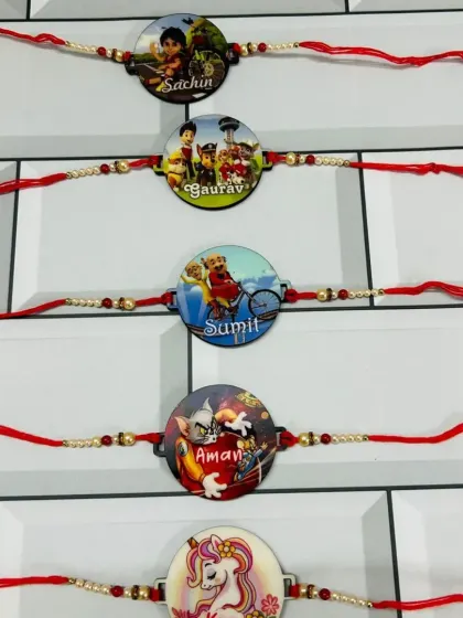 A collection of cartoon-themed rakhis for kids, featuring characters like Chhota Bheem and unicorns, each personalized with a name.