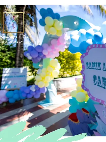 The entrance to a pastel carnival party, featuring a balloon arch in soft shades of blue, purple, and yellow.