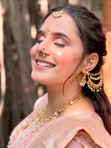 That blissful moment when the makeup is done and you feel absolutely beautiful. The dewy highlight on her cheekbones catches the light perfectly, giving her that signature bridal glow.