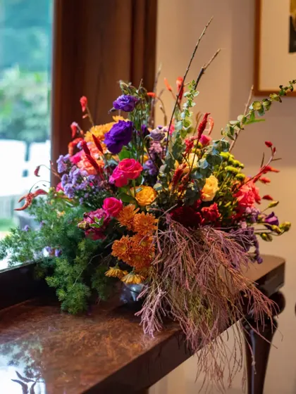 A smaller, yet equally vibrant, arrangement placed on a side table. We ensure the design theme is carried throughout the space with beautiful floral touches in every corner.