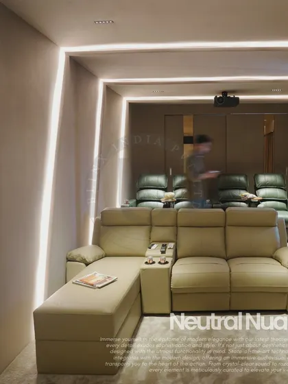 This home theater in Noida features a unique two-tiered seating arrangement with a comfortable L-shaped sofa in the front and traditional recliners in the back. The design uses subtle cove lighting and neutral tones to create a welcoming and versatile entertainment space.