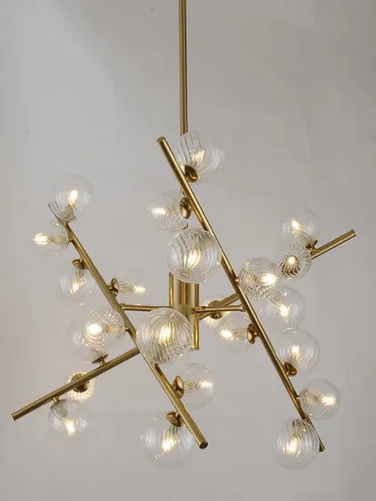 A classic sputnik chandelier with textured glass globes on a brass frame. This design offers a timeless modern look for any room.