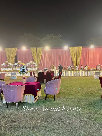A view across the lawn showing different seating arrangements, from small tables to lounge areas, with the catering setup in the background.