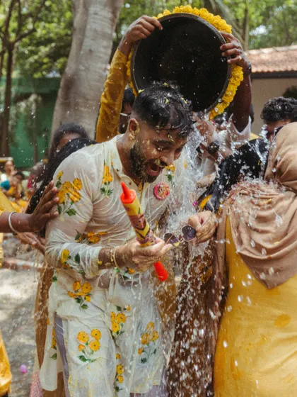 The groom gets a celebratory drenching with water during the Haldi ceremony, a moment of pure, uninhibited fun with friends and family.