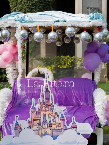 A magical Disney-themed carriage, draped in purple velvet and decorated with disco balls and balloons. This served as a fantastic photo prop and a throne for the birthday star.