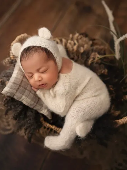 Another angle of the newborn in the bear romper, showing off the cute little ears on the bonnet.
