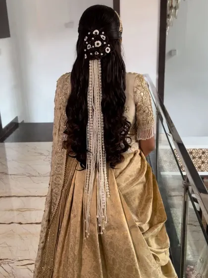 A stunning half-up style with soft curls and a beautiful cascading pearl accessory. This look is the epitome of modern bridal elegance.