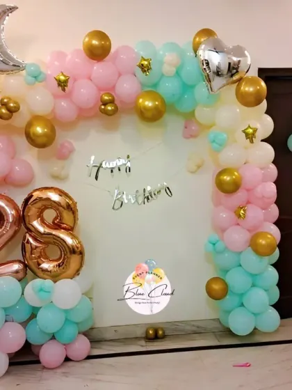 A pastel-themed wall decoration for a 28th birthday with foil numbers and moon and star accents.