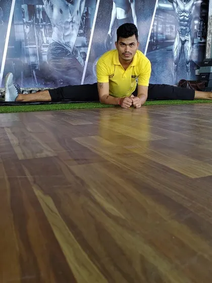 Working on flexibility against the gym's turf section. I use all parts of the gym to keep training varied.