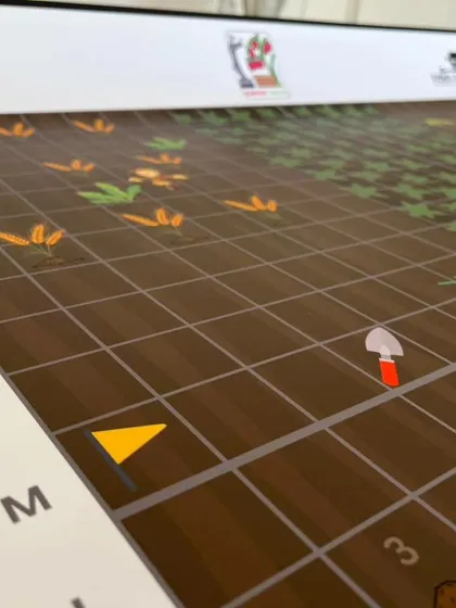 Another detail of the IRO Explorers mat, with grid coordinates and simple icons like a shovel, making it easy for young children to understand the programming tasks.