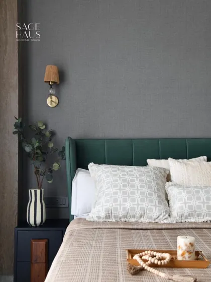 This bedroom balances plush textures, soft lighting, and earthy accents. The deep green headboard adds character and depth, while the layered neutral bedding brings softness, proving that a minimal aesthetic can still be full of personality.