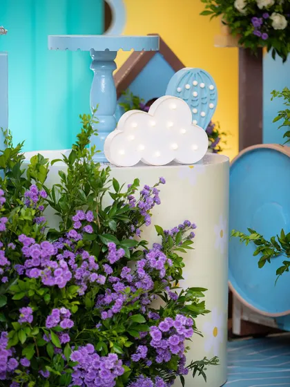 A light-up cloud prop adds a dreamy glow to the decor. I use various lighting elements to create a warm and magical ambiance.