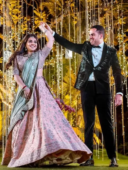 The perfect twirl. This shot captures the bride's lehenga in full motion as she dances with her groom, set against a backdrop of beautiful fairy lights.