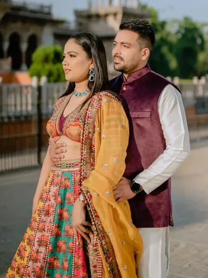A classic couple portrait that showcases the beautiful details of their traditional outfits and the impressive architecture of the Albert Hall Museum.