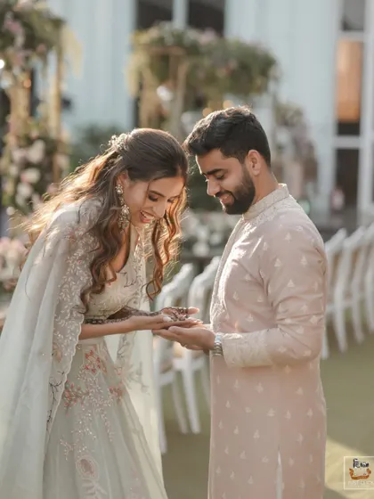 A sweet moment where the groom admires the bride's mehndi design.