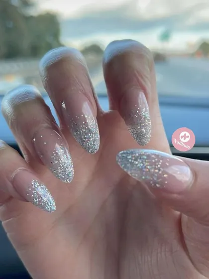 A simple yet stunning silver glitter fade on long, almond-shaped nails. This is my go-to for instant glam.
