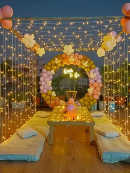 Here is a complete cabana-style seating arrangement for a rooftop party. I used a frame draped with fairy lights, a 'Bride to Be' neon sign, and a balloon ring to create a cozy and picture-perfect space for a bridal shower.