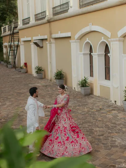 A romantic shot of the groom leading the bride for a dance in a beautiful outdoor courtyard.