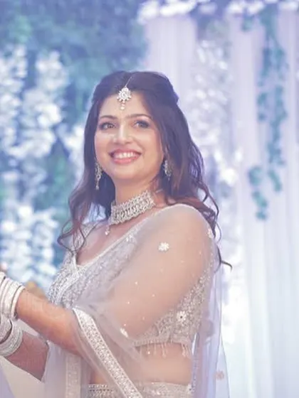 A lovely portrait of the bride, highlighting her soft, glowing makeup and the elegant half-up hairstyle.