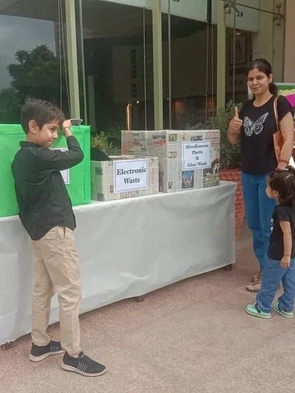 A mother and her two young children learn about waste segregation at a collection drive at RPS International School, where 43 families collected 238 kgs of dry waste.