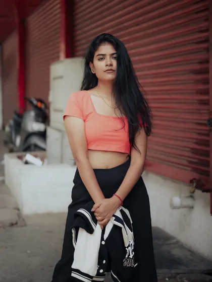 This is what Church Street style looks like. The model's casual outfit and direct gaze, set against the backdrop of red shutters, capture the authentic vibe of the city.