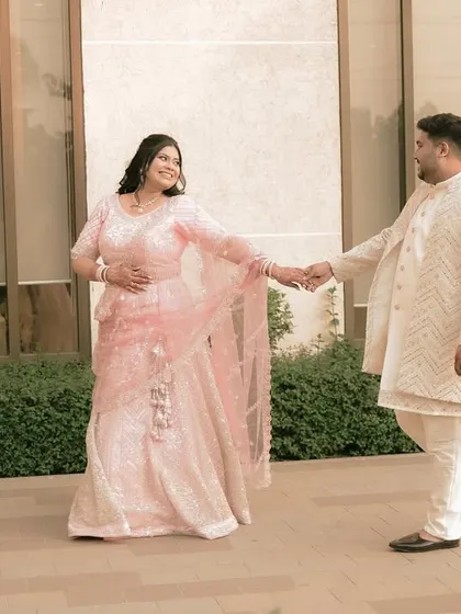 A romantic walking shot, with the bride leading the groom, showcasing their playful connection.