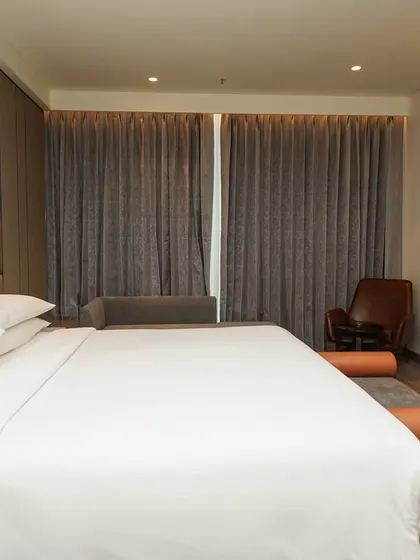 A perspective from the foot of the bed, focusing on the crisp linens and the room's ambient lighting. This detail shot adds to the overall sense of comfort and quality.